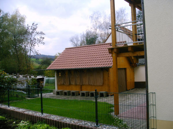 The backside of the house with a garage and a little garden