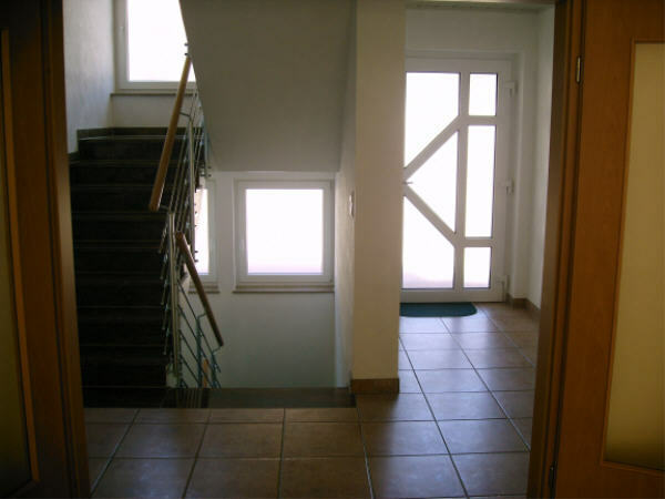 Stairwell with main door, upstairs to the top floor and downstairs to the basement